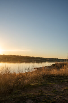 Golden light washes over calm lake at sunset