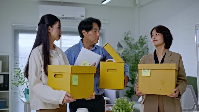 Group of Asian employees holding cardboard boxes after being fired, representing corporate layoff from AI disruption, unemployed staff, unemployment crisis business and modern technology