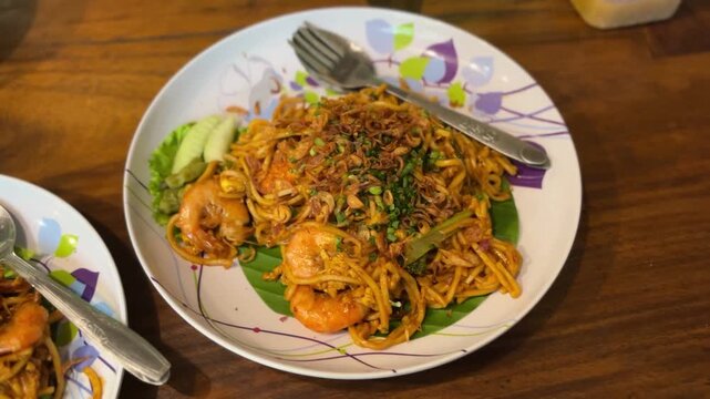 Delicious shrimp fried noodles served on a vibrant plate