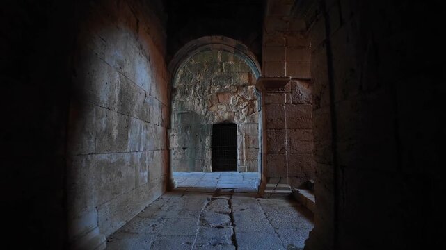 Interior view through a dark stone-vaulted corridor and archway inside the ancient Roman theater at Miletus, Turkey.