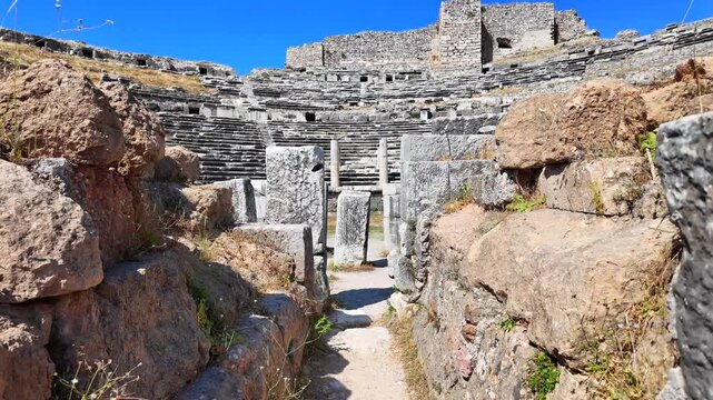 Close-up view of the ancient stone ruins and seating tiers at the Miletus archaeological site under a blue sky.