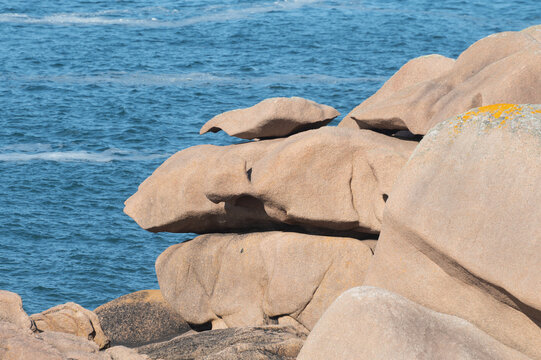 Heap of Ploumanac'h and Chateau de Costaeres iconic pink granite rock formation on C&ocirc;te de Granit Rose, Brittany. Massive balanced boulders creating natural sculptural monument on seashore, France