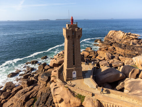 Aerial view, Lighthouse of Heap of Ploumanac'h and Chateau de Costaeres iconic pink granite rock formation on C&ocirc;te de Granit Rose, Brittany. Massive balanced boulders on seashore, France