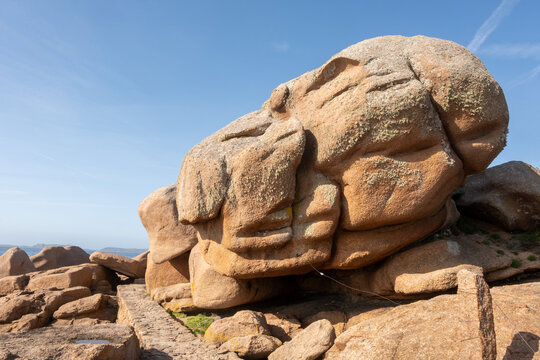 Heap of Ploumanac'h and Chateau de Costaeres iconic pink granite rock formation on C&ocirc;te de Granit Rose, Brittany. Massive balanced boulders creating natural sculptural monument on seashore, France