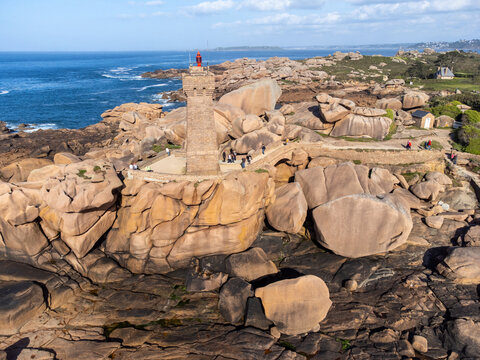 Aerial view, Lighthouse of Heap of Ploumanac'h and Chateau de Costaeres iconic pink granite rock formation on C&ocirc;te de Granit Rose, Brittany. Massive balanced boulders on seashore, France