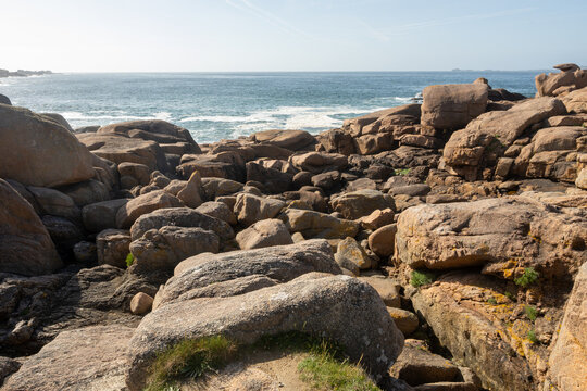 Heap of Ploumanac'h and Chateau de Costaeres iconic pink granite rock formation on C&ocirc;te de Granit Rose, Brittany. Massive balanced boulders creating natural sculptural monument on seashore, France