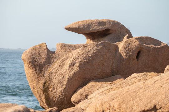 Heap of Ploumanac'h and Chateau de Costaeres iconic pink granite rock formation on C&ocirc;te de Granit Rose, Brittany. Massive balanced boulders creating natural sculptural monument on seashore, France