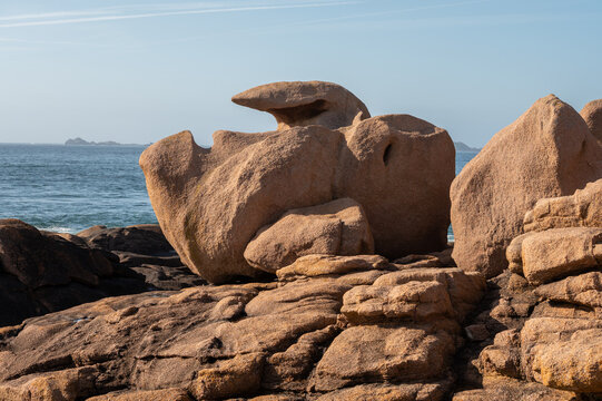 Heap of Ploumanac'h and Chateau de Costaeres iconic pink granite rock formation on C&ocirc;te de Granit Rose, Brittany. Massive balanced boulders creating natural sculptural monument on seashore, France