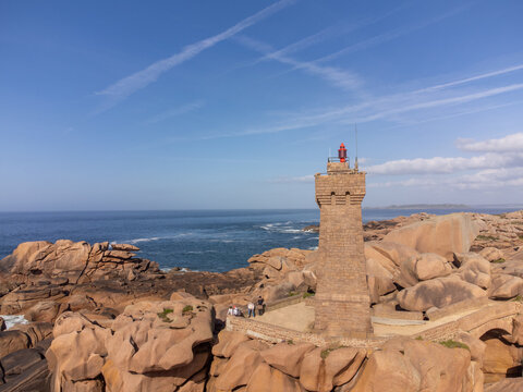 Aerial view, Lighthouse of Heap of Ploumanac'h and Chateau de Costaeres iconic pink granite rock formation on C&ocirc;te de Granit Rose, Brittany. Massive balanced boulders on seashore, France