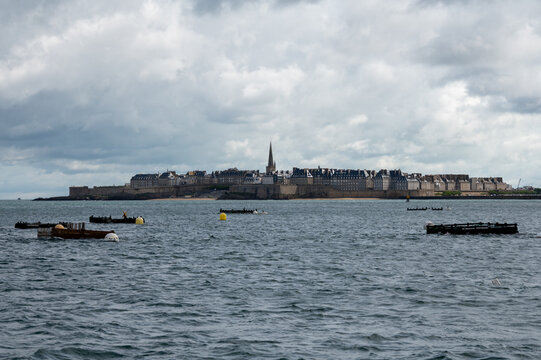 High tide in Dinard, Brittany with view toward walled city of Saint-Malo. Coastal Atlantic landscape with boats and dramatic tidal range of Emerald Coast, France.