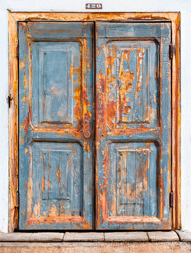 Rustic old wooden door with peeling paint and rusty doorknob in Santiago, Chile in South America