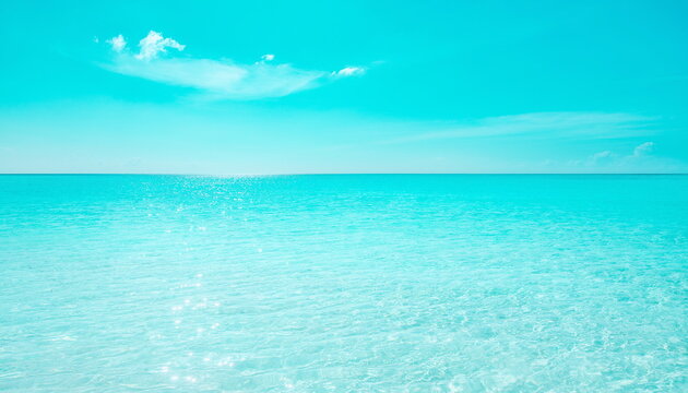 Vibrant turquoise tropical ocean surface under clear blue sky 鮮やかなターコイズブルーの熱帯の海面と晴れ渡る空の背景素材