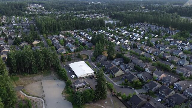 Centralized park amenities serve surrounding subdivisions off Black Diamond Road in Maple Valley, Washington. Drone captures integrated play equipment bordering lush community green space zones