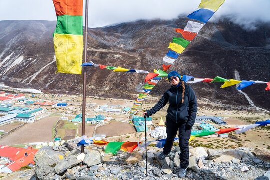 Mujer senderista entre banderitas budistas en el poblado de Dingboche, en su camino al Campamento Base del Everest, en Nepal.