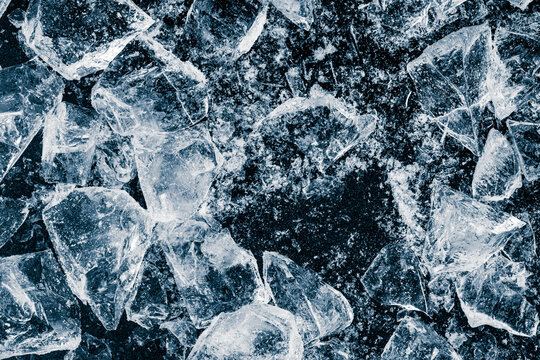 Pieces of crushed ice cubes on a black background. Ice debris pattern.