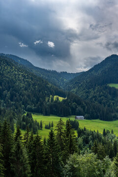 Bregenz forest in Austria on a cloudy summer day. alpine farmhouse under a tightrope under changing weather. holiday destination for hiker and climber and in winter skiing