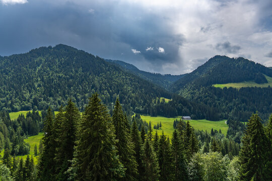 Bregenz forest in Austria on a cloudy summer day. alpine farmhouse under a tightrope under changing weather. holiday destination for hiker and climber and in winter skiing
