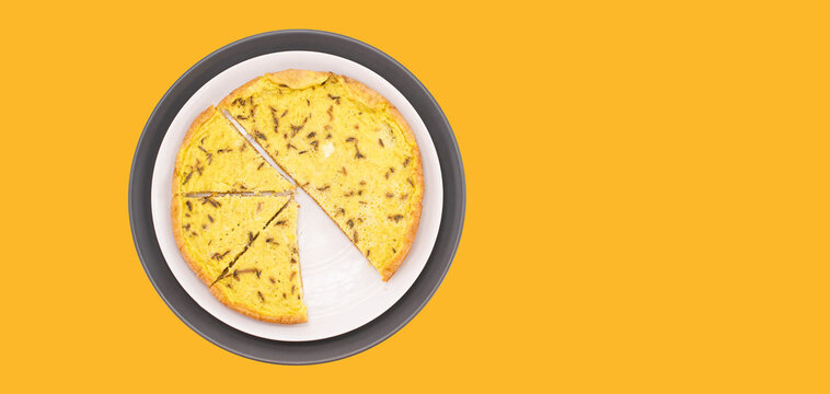 Immagine primo piano con vista da sopra di piatto con frittata alle erbe su uno sfondo di colore giallo