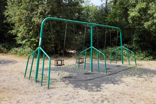 empty urban playground in a summer drought with dead brown grass