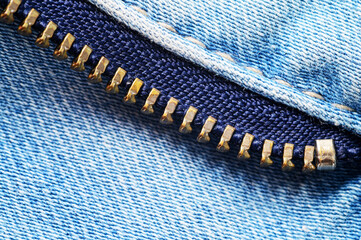 Close up view of metallic zipper teeth on blue denim fabric texture © dimas830