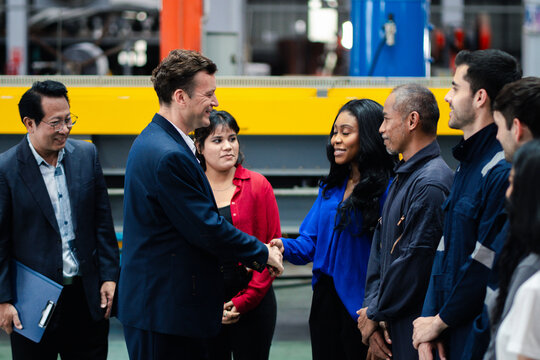 Business collaboration in manufacturing. Executives and factory professionals exchange a handshake during an industrial meeting. Partnership, teamwork, leadership, industry, collaboration