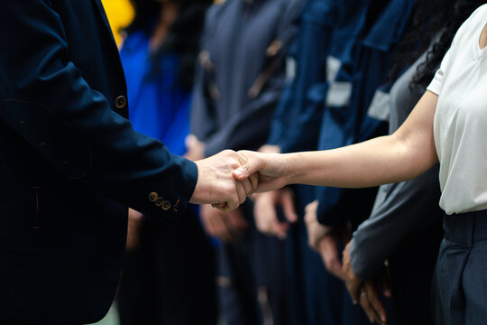 Business collaboration in manufacturing. Executives and factory professionals exchange a handshake during an industrial meeting. Partnership, teamwork, leadership, industry, collaboration