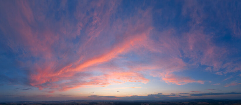 Colorful Sunset Sky from Above with Panoramic Format and Copy Space. Ideal for background use. Colors: pink, blue, orange.