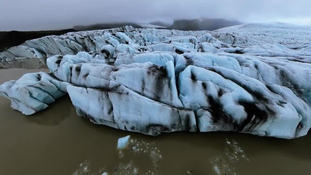 Low Altitude Aerial Drone Flies Alongside Glacier Wall Volcanic Ash Iceland