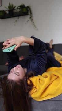 Vertical screen Morning begins with endless scrolling as a young woman stays absorbed in social media chasing quick dopamine instead of fully waking up for the day