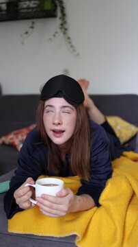Vertical screen Coffee in bed is the perfect morning recipe for this young woman who starts every new day with her favorite cup before doing anything else