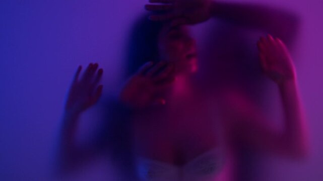 Anonymous multiracial couple making love behind the frost glass. They enjoy foreplay together showing love and desire. 