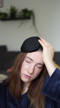 Vertical screen The first moments after waking capture a young woman still fighting sleep with heavy eyes and a tired expression before she fully starts her morning routine