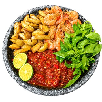 sambal udang Indonesian served with crispy potato wedges, fresh basil, and lime slices on a stone mortar