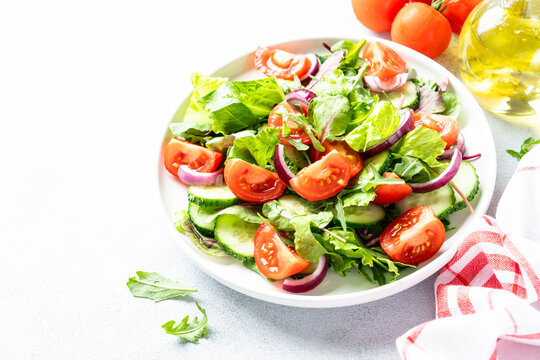 Green salad with leaves, tomatoes, cucumber.