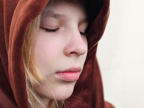 Portrait of a teenage child with thoughtfully closed eyes. Emotions: sadness