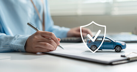 Female client signing car insurance document or auto loan contract with blue toy car and virtual protection shield icon. Vehicle safety guarantee, secure auto finance agreement. © Father_Studio