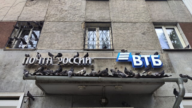 Irkutsk, Russia - July 18, 2026. A lot of Pigeons Sitting on the Entrance Canopy of Old Building