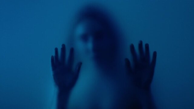Anonymous woman putting hand on frosted glass. Concept of looking for help or anonymity. 