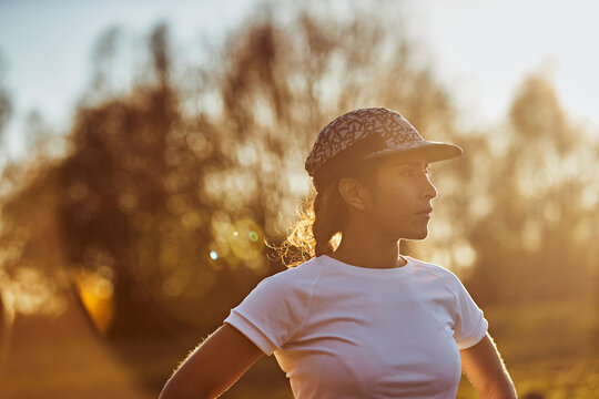 Female Runner Standing In Golden Hour Sunlight