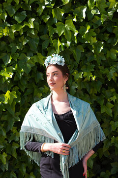 Portrait of a beautiful woman dancing flamenco in Seville, Spain. She is wearing a black gypsy dress with ruffles and a flower in her hair. Flamenco, a UNESCO Intangible Cultural Heritage.
