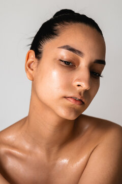 A young woman with moisturized skin and bare shoulders. Skincare
