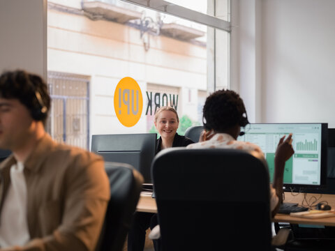 Colleagues talking at work in call centre office 