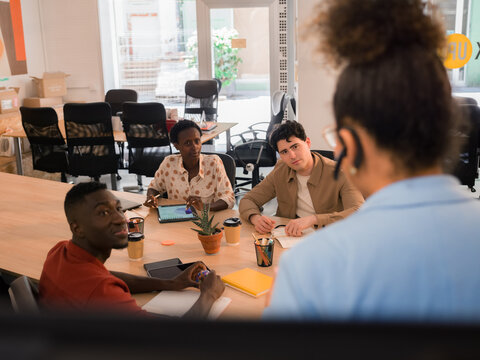 Attentive employees are listening to businesswoman at meeting 