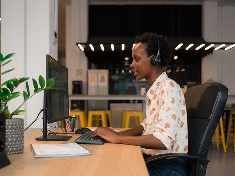Woman working at office using computer and headset 