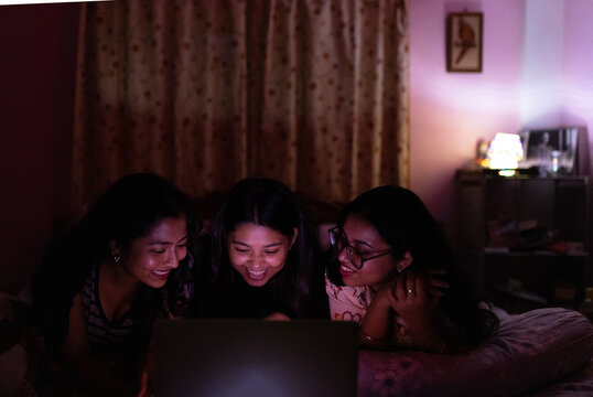 Three Young Woman enjoying movie inside home
