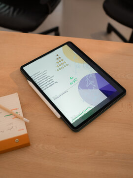 Tablet computer with analytical data on table at office 