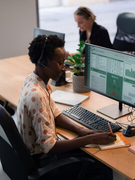 Woman Working at a Computer Desk With Headset in Call Centre 