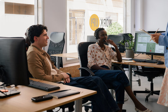Employees listening to their supervisor at office 