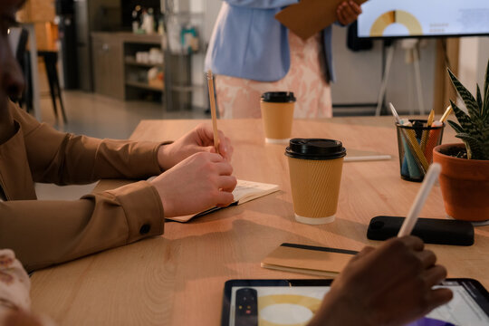Meeting at a Workspace With Coffee and Digital Devices Present