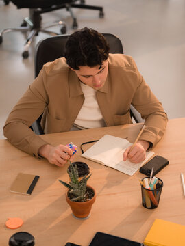 Young man is taking notes during meeting 